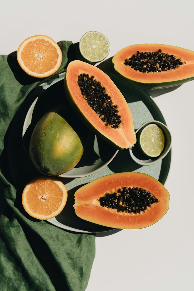 Papaya, citrice și mango aranjate pe o masă